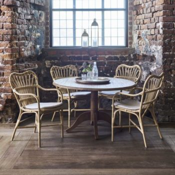 Chaises de repas en rotin naturel autour d'une table ronde en bois