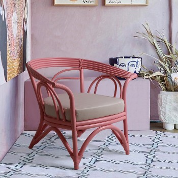 Fauteuil en rotin de couleur rose avec coussin