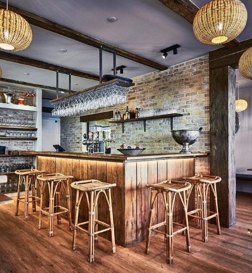 Meuble bar d'intérieur en bois avec tabourets hauts en rotin